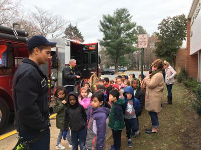 Photo of kindergarten students with firefighters