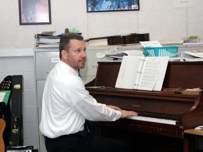 photo of a teacher playing the piano