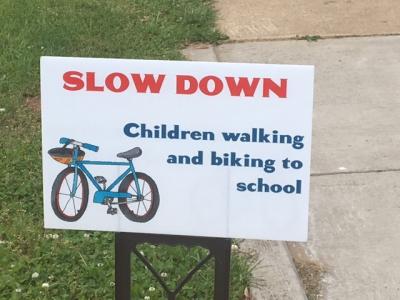 sign that says slow down children walking and biking to school